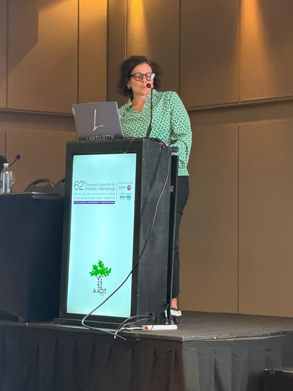 Disertante en el 62° Congreso Argentino de Ortopedia y Traumatología 2025, con el atril de AAOT