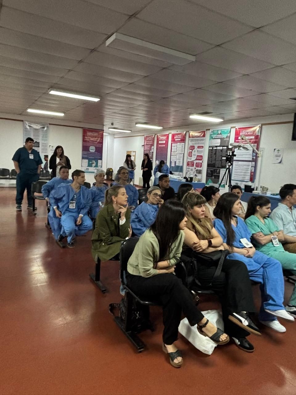 Participantes del taller sentados en el aula, con pósters científicos de fondo
